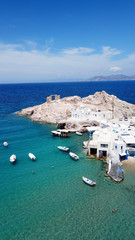 Obraz premium Aerial drone bird's eye view photo of picturesque fishing village of Firopotamos with traditional boat docks called syrmata, small chapel and turquoise water beach, Milos island, Cyclades, Greece