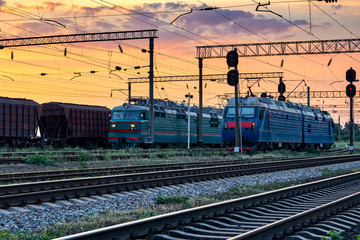 Fototapeta na wymiar railroad infrastructure during beautiful sunset and colorful sky, trains and wagons, transportation and industrial concept
