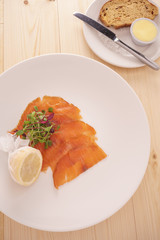 Slices of Wild Smoked Scottish Salmon with a Muslin Wrapped Half Lemon