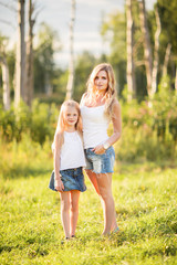 Fototapeta premium Family picture of blonde young mother and daughter outdoors