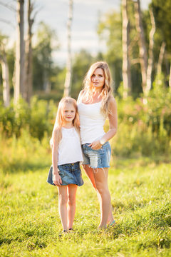 Family picture of blonde young mother and daughter outdoors