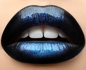 Fototapeta premium Macro and close-up creative make-up theme: beautiful female lips with black and blue lipstick