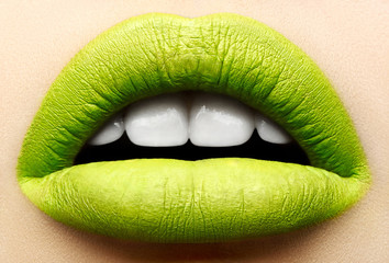 Macro and close-up creative make-up theme: beautiful female lips with a matte green lipstick