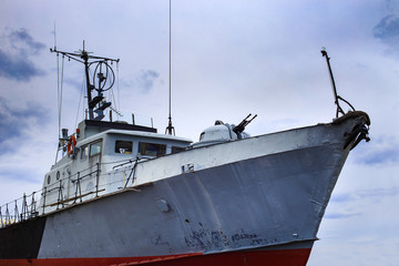 Old soviet military warship as viewed from water level on sky background