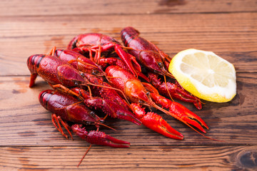 Closeup of boiled crawfish with lemon slice on wooden table