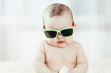 Funny baby in sunglasses with spoon