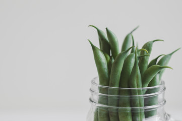 Fresh green beans in a jar on white background. Food ingredient. Raw plant