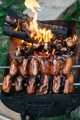 Grilling sausages on barbecue grill