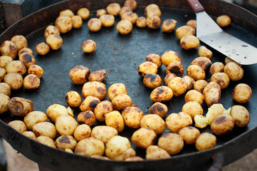 Young potatoes on big frying pan. Roasted outside. Street food.