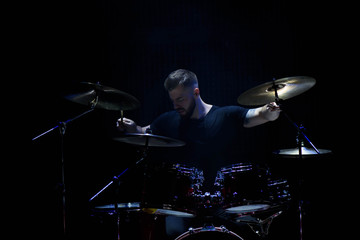 Fototapeta premium music, people, musical instruments and entertainment concept - male musician with drumsticks playing drums and cymbals at concert or studio