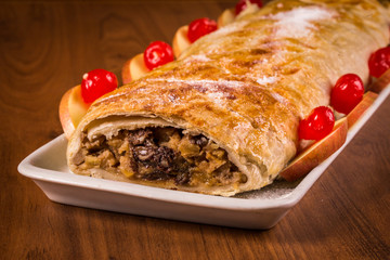 Strudel de maça inteiro em mesa de madeira