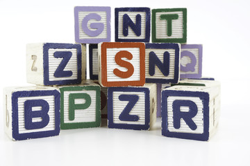 Colored wooden letter blocks on a white background with copy space