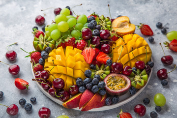 delicious fruits and berries platter.  Mango, kiwi, strawberry, grape, cherry, blueberry, peach and passion fruit