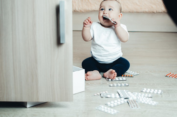 baby, girl sitting on the floor in the hands of pills