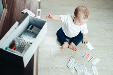 baby, girl sitting on the floor in the hands of pills
