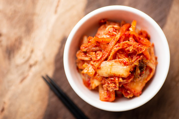 Kimchi cabbage in a bowl with chopsticks, top view, Korean food - obrazy, fototapety, plakaty