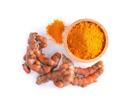 curcuma powder in a bowl and root on white background