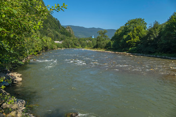 fast mountain river with rapids and forest shores