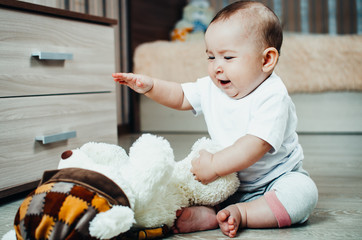 Fototapeta premium baby on the floor playing with a soft toy