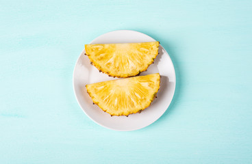 Slice pineapple on white dish, top view, tropical fruit