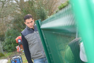 Man looking down garden fence