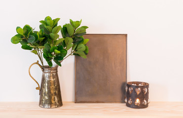 Vintage home decor composition with metal objects and green plant