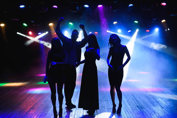 Young happy people are dancing in club. Nightlife and disco concept.