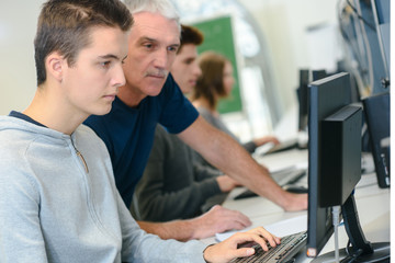 teacher helping an it student with her work