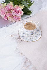 Coffee and bouquet of pink roses in bed, romance and coziness. Good morning. Breakfast in bed. Copy space,