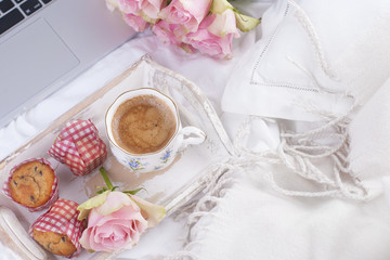 Fototapeta na wymiar Coffee and bouquet of pink roses in bed, romance and coziness. Good morning. Breakfast in bed. Copy space,