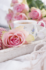 Coffee and bouquet of pink roses in bed, romance and coziness. Good morning. Breakfast in bed. Copy space,