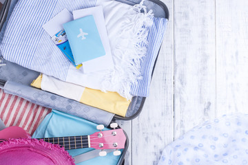 Suitcase for vacation, clothing and passport. Accessories for the sea and rest. Bright colors. Copy space.