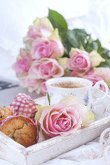 Coffee and bouquet of pink roses in bed, romance and coziness. Good morning. Breakfast in bed. Copy space.
