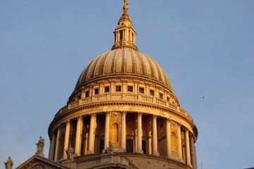 View from the bottom of the dome of the ancient temples of the city of London against the background of a cloudy blue sky at sunset.