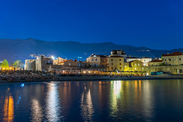 Fototapeta premium The lights of the night city are reflected in the coastal waters.