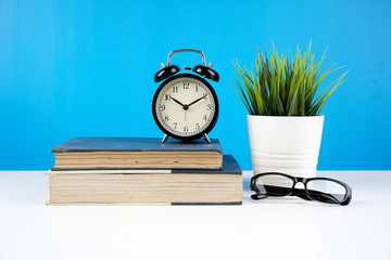 Naklejka premium Education concept. An old book, eyeglasses over blue background