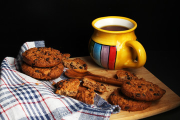 Cookies with chocolate chips and tea against dark background