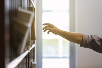  man"s arm reaching to take mail
