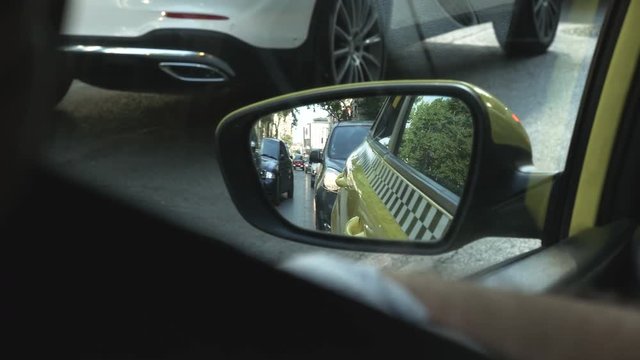 City Traffic From the Rear View Mirror of a Taxi
