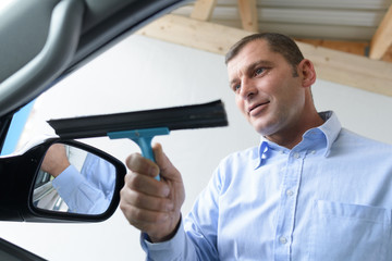 Man cleaning car window