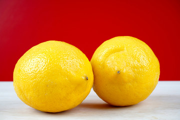 Lemon on a wooden table over red background