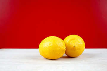 Lemon on a wooden table over red background