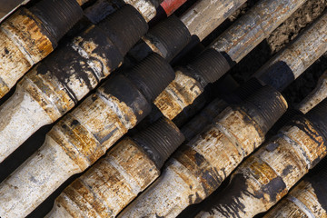 Oil Drill pipe. Rusty drill pipes were drilled in the well section. Downhole drilling rig. Laying the pipe on the deck. View of the shell of drill pipes laid in courtyard of the oil and gas warehouse.