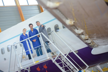 Three people on platform next to aircraft - obrazy, fototapety, plakaty