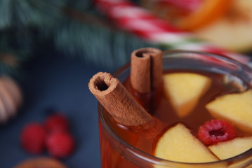 Still life hot drink seasonal and holidays concept. Winter, Christmas hot beverage in a glass with fruits and spices on a wooden background. Selective focus, top view