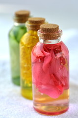 Three glass vial bottles of fresh natural plant based skin care facial toners with copy space. Organic herbal, plant and flower infusions for face and body. Cucumber, marigold and rose.
