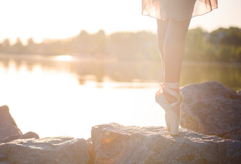Talented ballerina with pointe shoes on the beach at sunset © Jane_S