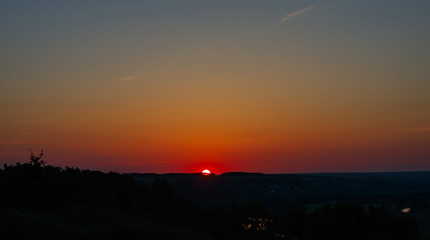 Cloudless sky during sunset. The sun is on the horizon line..