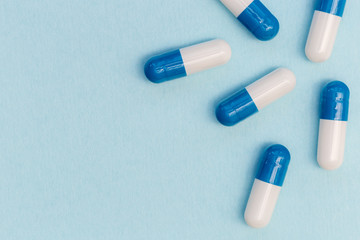 Drugs pills capsules on blue background abstract concept
