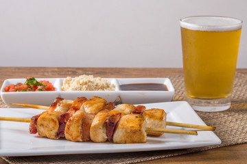 Espetinho de frango com farofa , molho e chopp